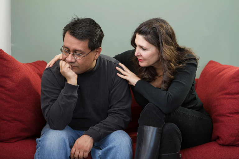 a woman consoles an upset man trying to cope with living with an alcoholic